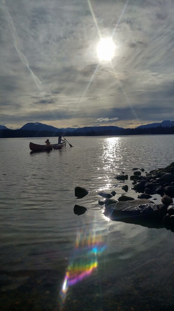 Image of a lake, canoe, and canoe paddlers 