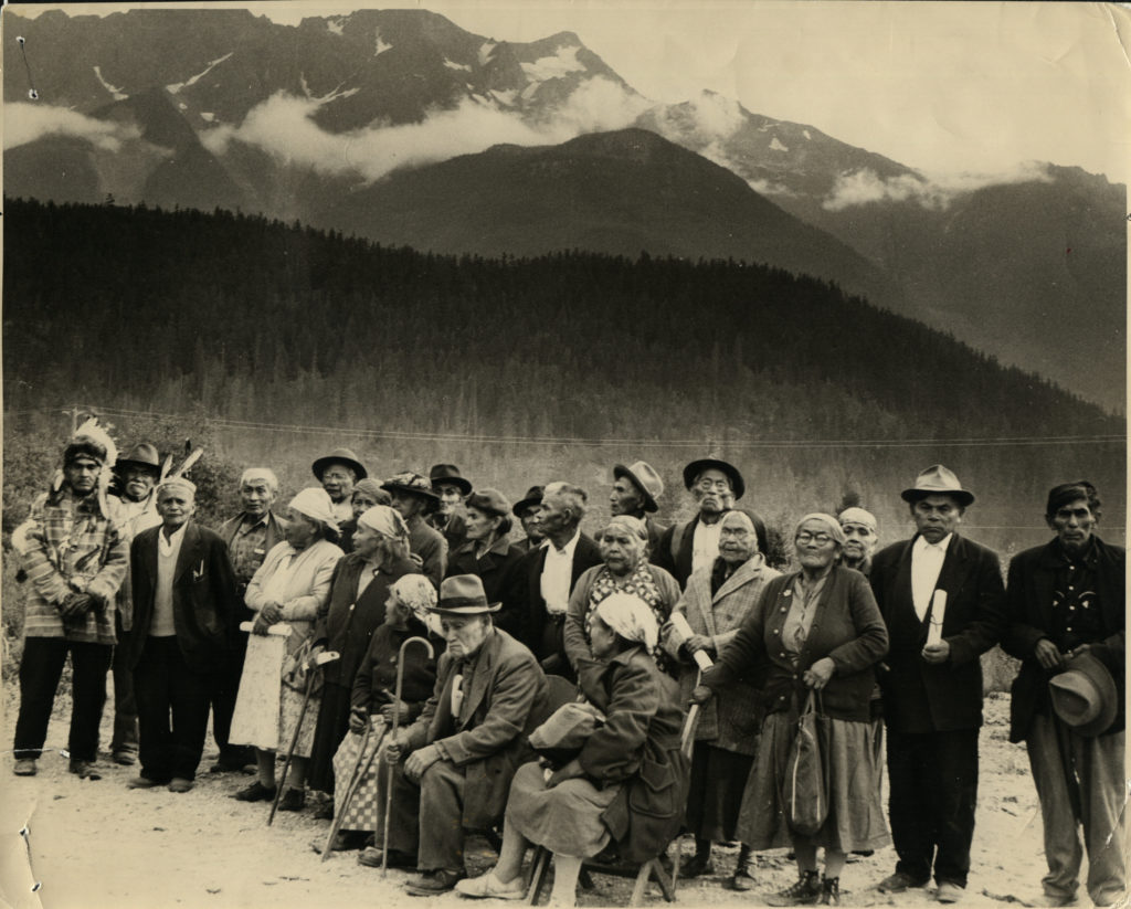 Black and white group photo with mountains in the background 